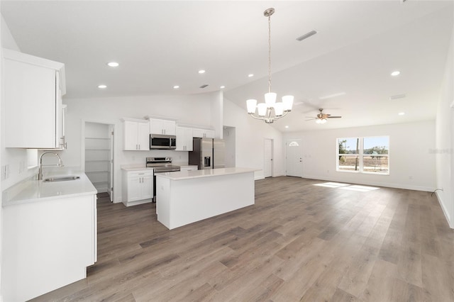 kitchen with sink, white cabinetry, a kitchen island, pendant lighting, and stainless steel appliances