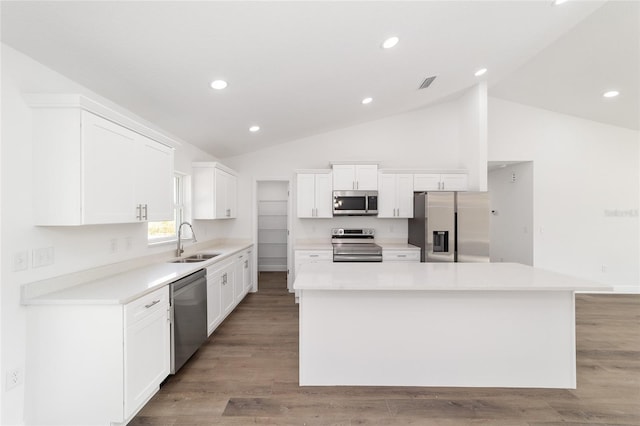 kitchen featuring sink, appliances with stainless steel finishes, white cabinetry, a center island, and light wood-type flooring