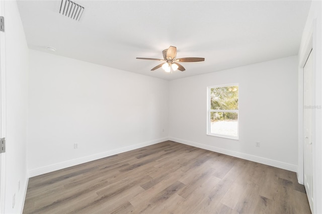 empty room with ceiling fan and light hardwood / wood-style floors