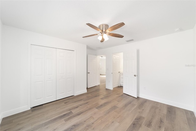 unfurnished bedroom featuring ceiling fan, a closet, and light wood-type flooring