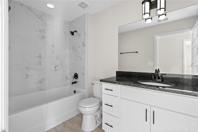 full bathroom featuring vanity, tiled shower / bath combo, toilet, and hardwood / wood-style flooring