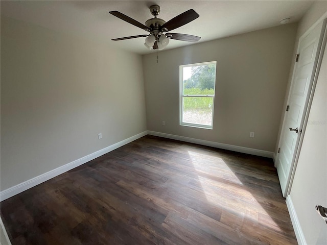 unfurnished room with ceiling fan and dark wood-type flooring