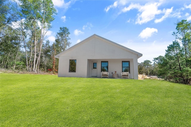 rear view of house featuring a lawn