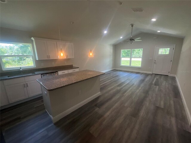 kitchen with white cabinets, a kitchen island, dark hardwood / wood-style flooring, lofted ceiling, and sink