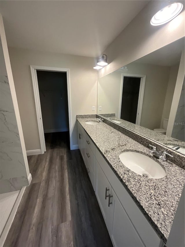 bathroom featuring wood-type flooring, vanity, and toilet