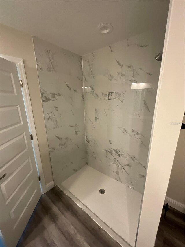 bathroom featuring a tile shower and hardwood / wood-style flooring