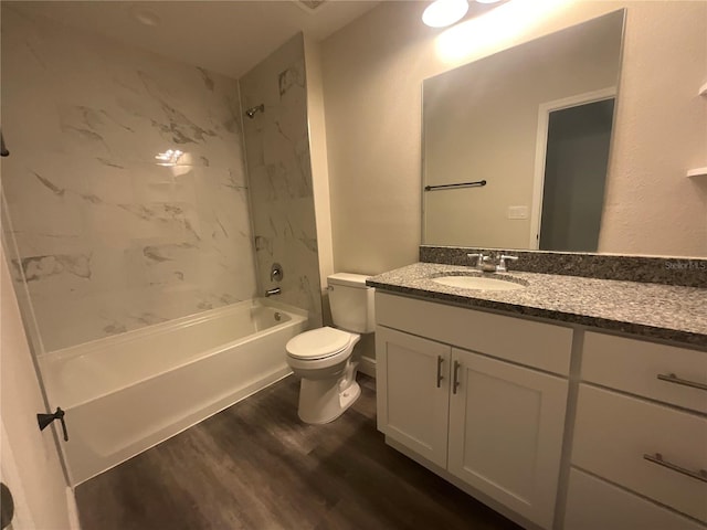 full bathroom with wood-type flooring, vanity, tiled shower / bath combo, and toilet