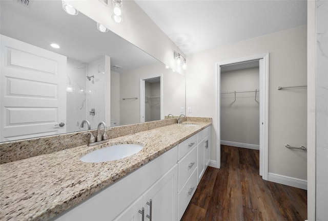 bathroom featuring hardwood / wood-style flooring, a shower, and vanity