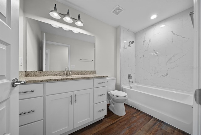 full bathroom featuring hardwood / wood-style floors, toilet, vanity, and tiled shower / bath