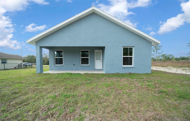 rear view of property with a lawn and a patio area