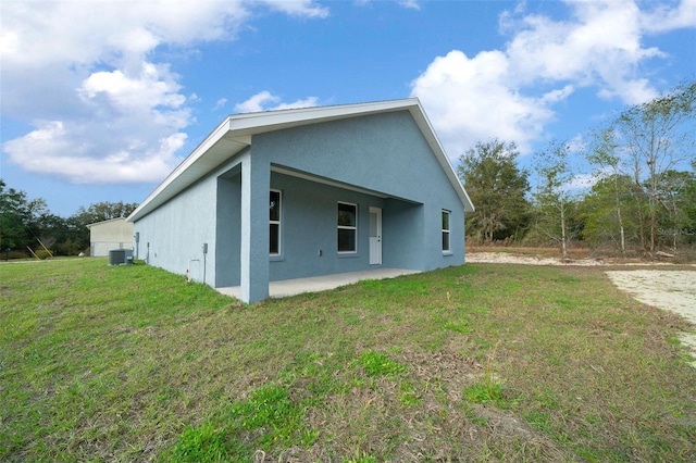 view of property exterior featuring a patio, a yard, and central air condition unit