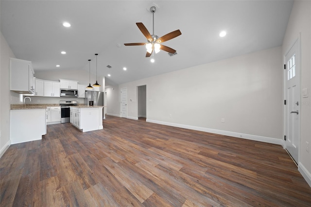 kitchen featuring appliances with stainless steel finishes, white cabinets, decorative light fixtures, a kitchen island, and sink