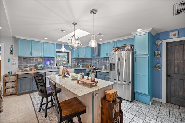 kitchen featuring a kitchen breakfast bar, backsplash, a center island, light tile patterned flooring, and stainless steel appliances