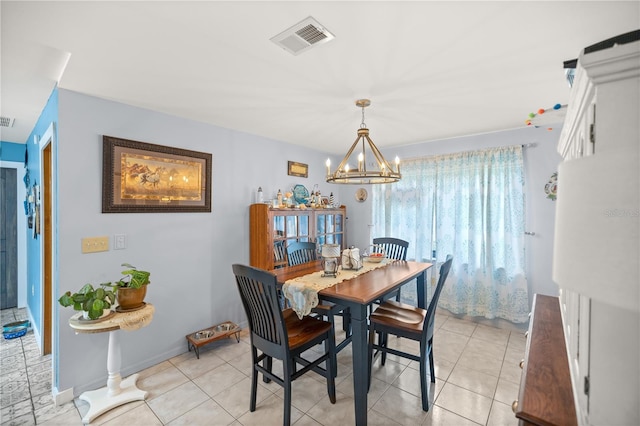 tiled dining space featuring an inviting chandelier