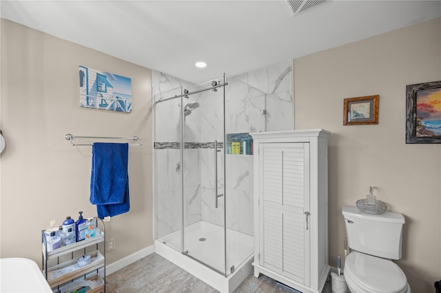 bathroom with toilet, hardwood / wood-style flooring, and walk in shower