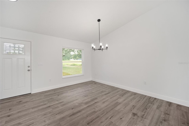 interior space with a chandelier, hardwood / wood-style floors, and vaulted ceiling