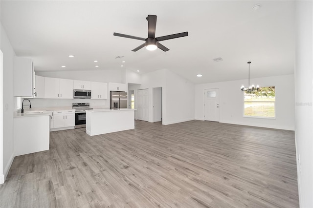 kitchen featuring white cabinetry, sink, light hardwood / wood-style floors, vaulted ceiling, and appliances with stainless steel finishes