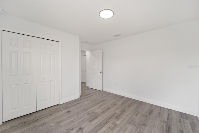 unfurnished bedroom featuring light wood-type flooring and a closet