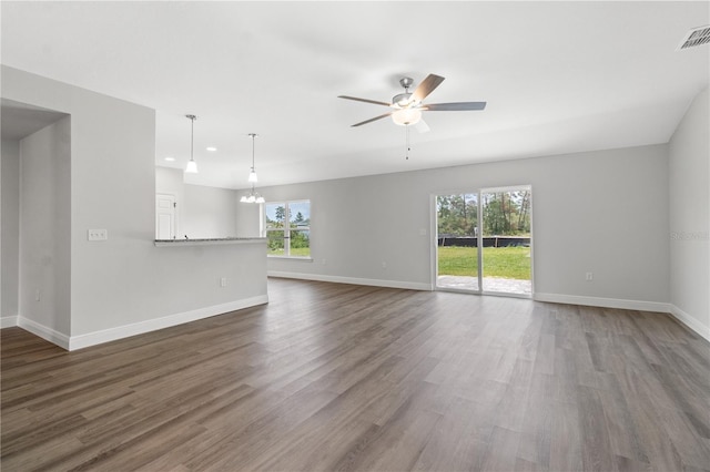 unfurnished living room with visible vents, baseboards, ceiling fan with notable chandelier, recessed lighting, and dark wood-style floors