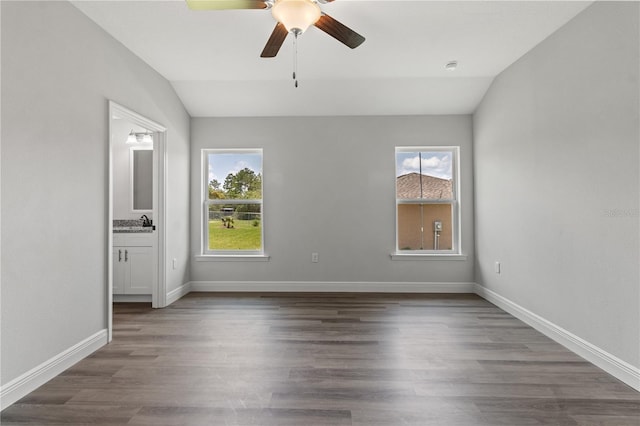 spare room with baseboards, wood finished floors, a ceiling fan, and vaulted ceiling