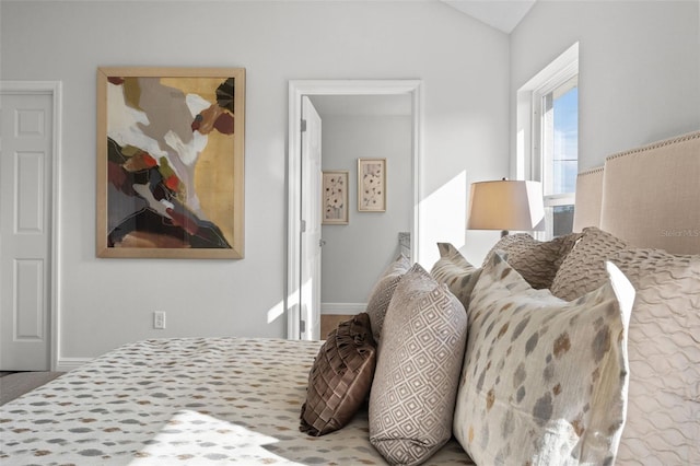 bedroom featuring vaulted ceiling and baseboards