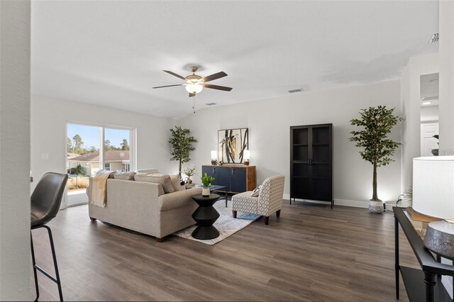 living room with baseboards, dark wood-style floors, visible vents, and ceiling fan