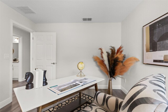 office with visible vents, dark wood-type flooring, and baseboards