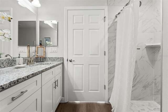 full bath with curtained shower, wood finished floors, and vanity