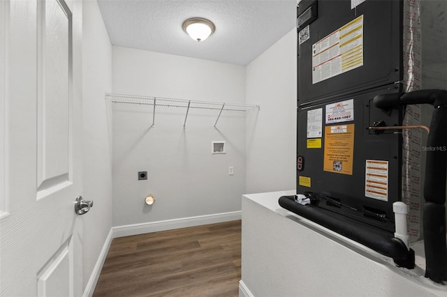 laundry room with hookup for a washing machine, wood finished floors, baseboards, laundry area, and a textured ceiling