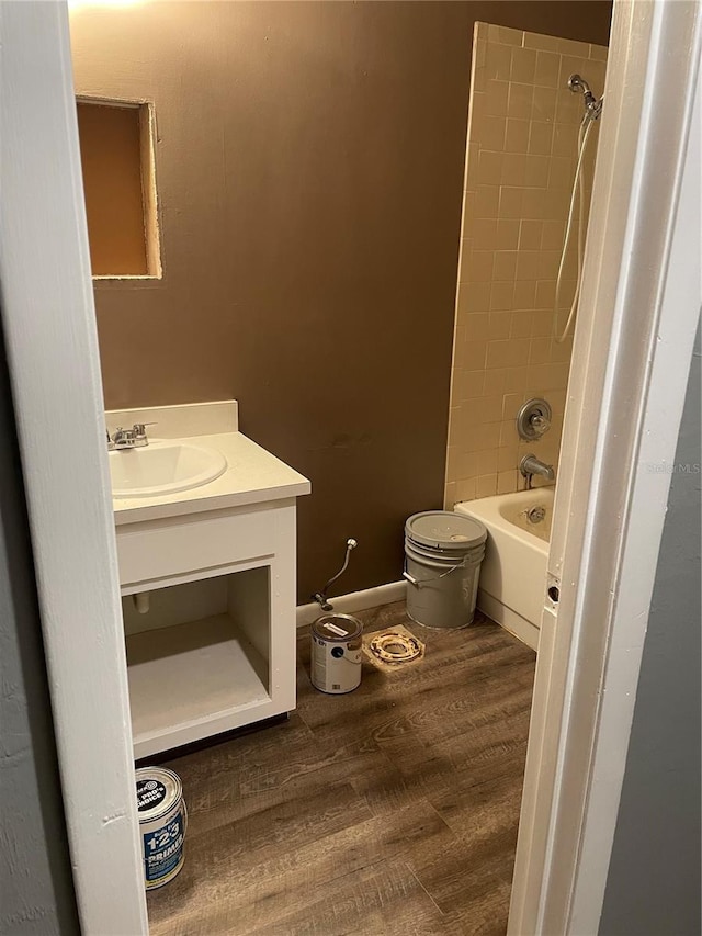 full bathroom with hardwood / wood-style flooring, toilet, vanity, and tiled shower / bath