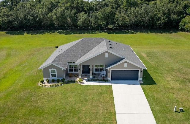 view of front of property featuring cooling unit, a garage, and a front lawn