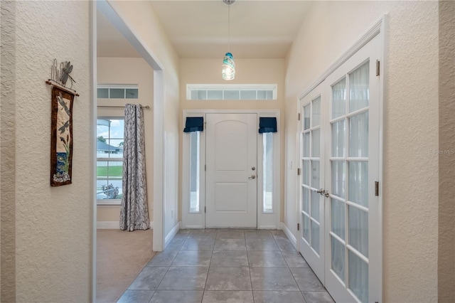 foyer entrance with tile patterned flooring and french doors