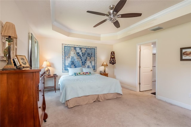 carpeted bedroom featuring ceiling fan, ornamental molding, and a tray ceiling