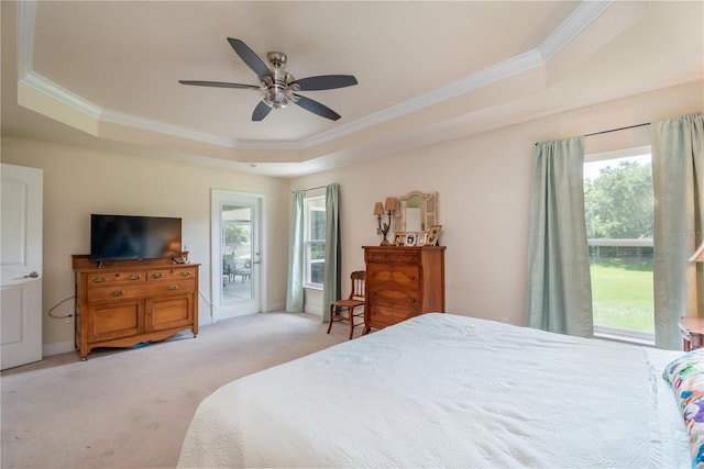 carpeted bedroom with ceiling fan, crown molding, access to outside, and a tray ceiling