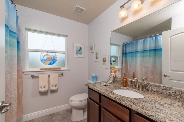 bathroom featuring tile patterned flooring, vanity, toilet, and walk in shower