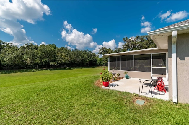 view of yard featuring a sunroom and a patio