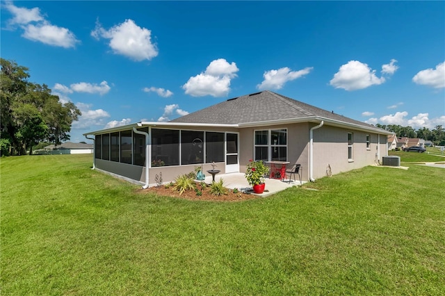 back of property with a lawn, a sunroom, a patio, and central AC