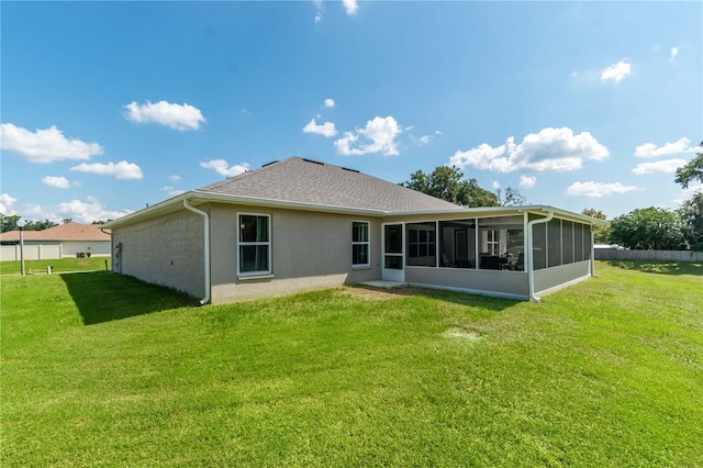 back of house featuring a lawn and a sunroom