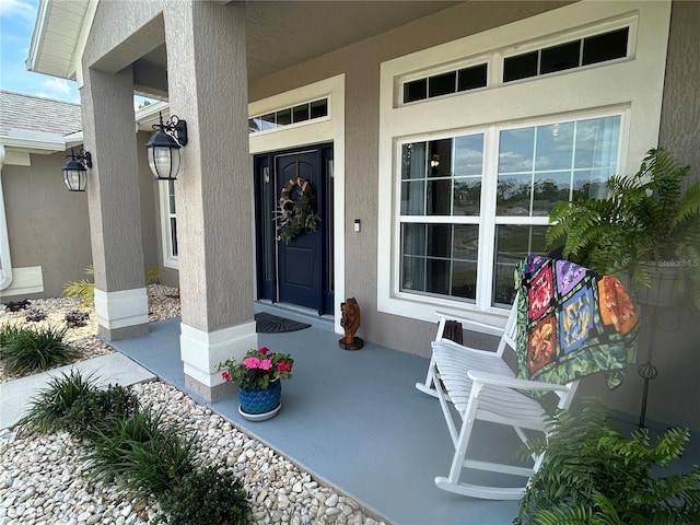 25 NW 45th Loop, Ocala, FL 34475 - doorway to property featuring covered porch and stucco siding