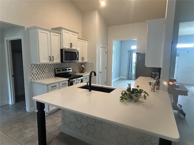 25 NW 45th Loop, Ocala, FL 34475 - kitchen with stainless steel appliances, backsplash, a sink, a peninsula, and a breakfast bar area