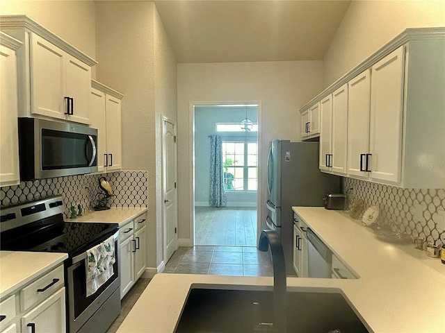 25 NW 45th Loop, Ocala, FL 34475 - kitchen featuring light countertops, backsplash, appliances with stainless steel finishes, and white cabinetry