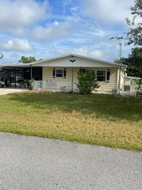 view of front of house with a carport and a front lawn