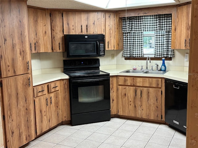 kitchen with black appliances, sink, and light tile patterned floors