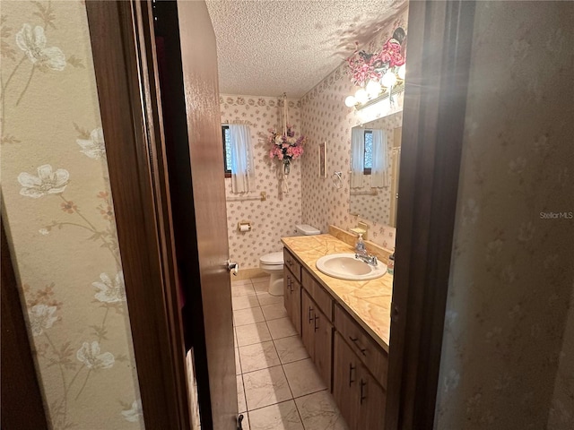 bathroom featuring a textured ceiling, vanity, toilet, and tile patterned flooring