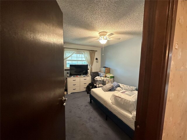 carpeted bedroom with a textured ceiling and ceiling fan