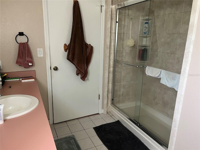 bathroom with tile patterned floors, vanity, and a shower with shower door