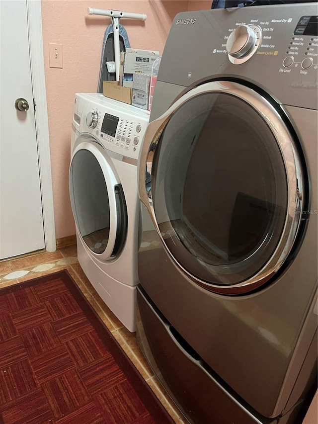 laundry area with washing machine and dryer and dark tile patterned floors