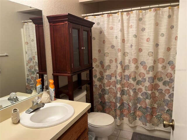 bathroom with toilet, vanity, and tile patterned floors