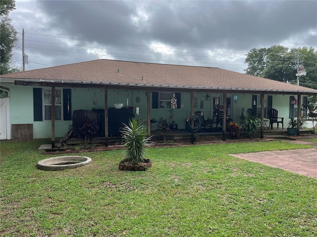 rear view of house with a porch and a yard