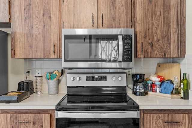 kitchen with appliances with stainless steel finishes and tasteful backsplash